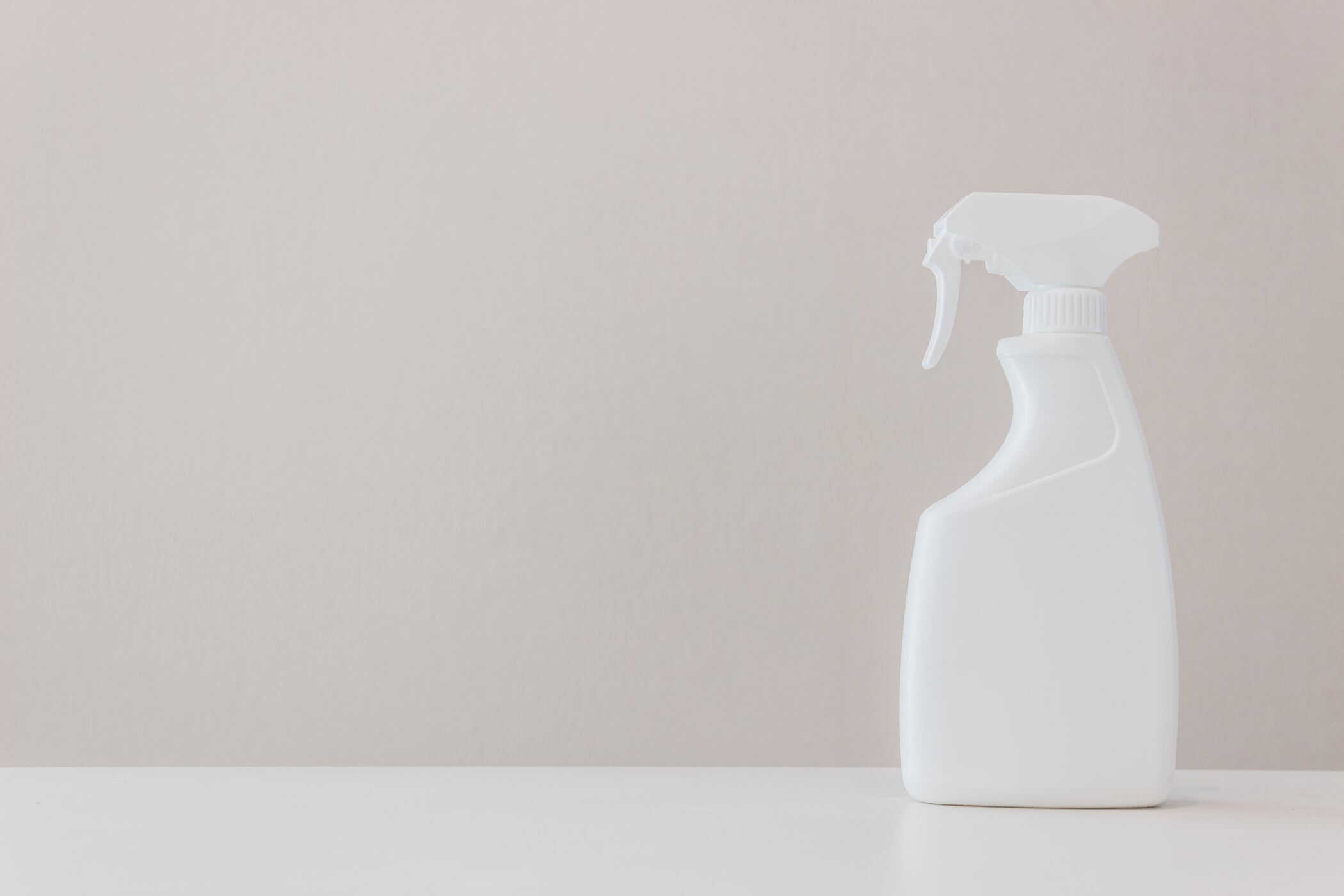 cleaning product spray bottle on a neutral background